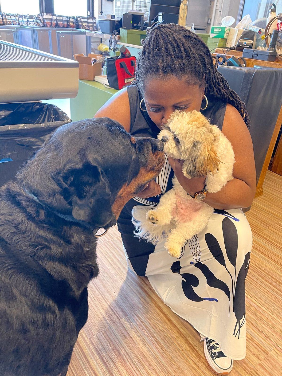 Dr. Atkinson-Spinks holding a small patient while Bear leans in to reassure him