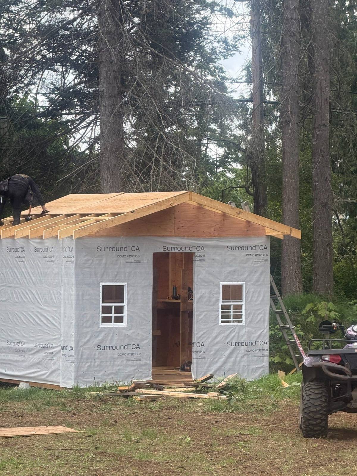 A newly framed cat house on the property with the roof going on