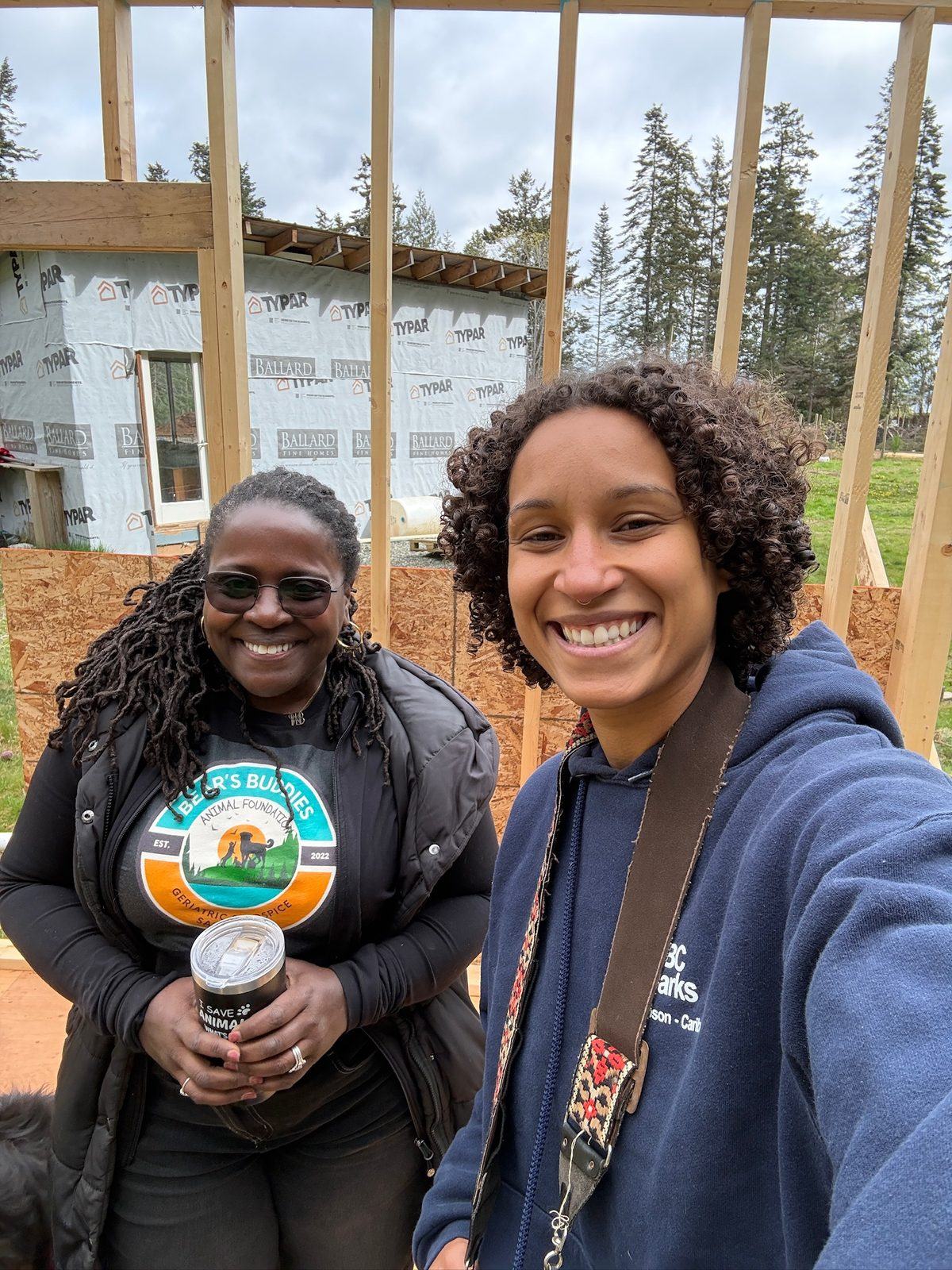 Dr. Atkinson-Spinks with a volunteer standing in front of the framed building